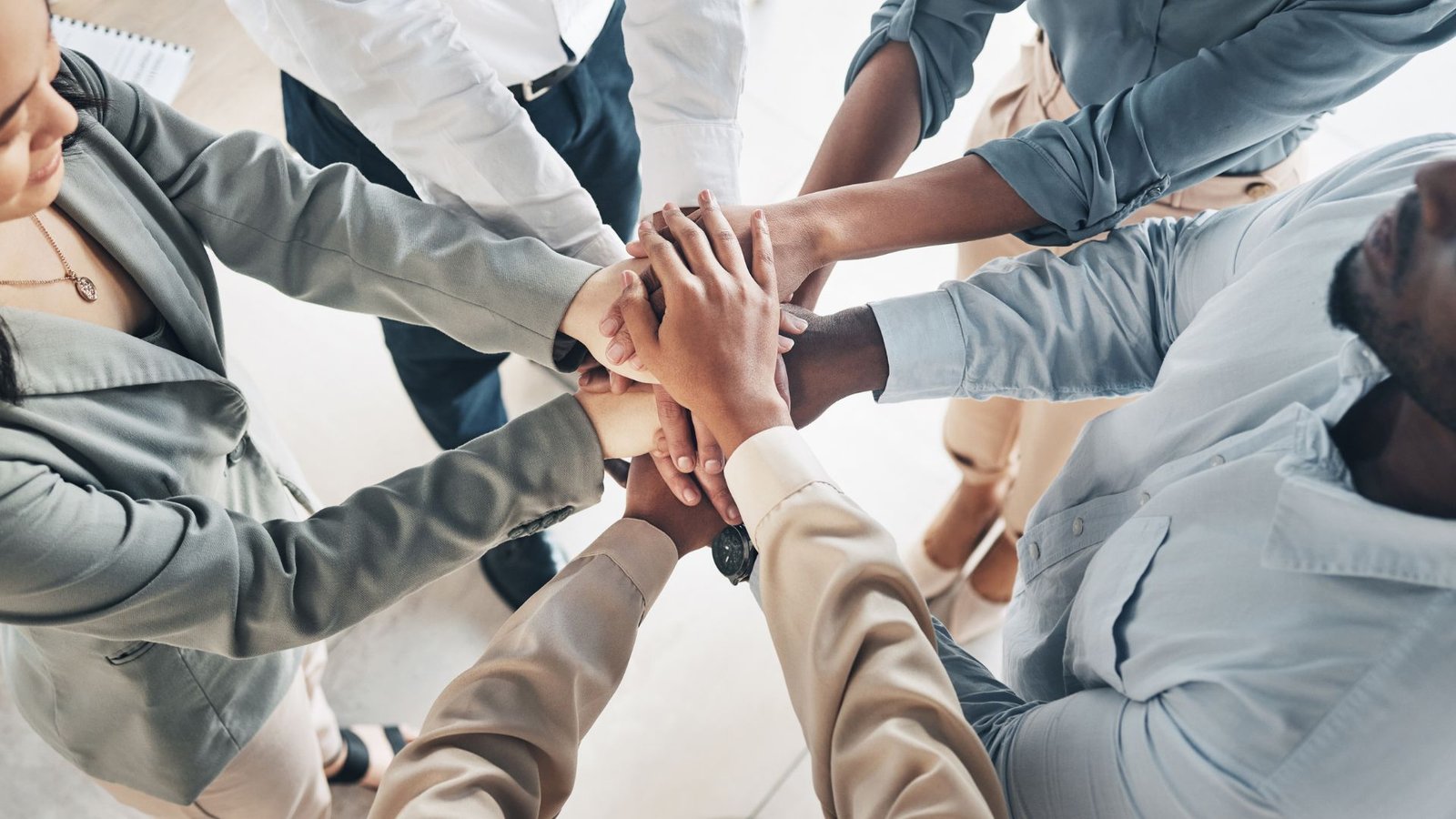 Team hands stacked together, representing employer partnerships